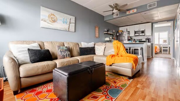 A living room with a sofa, a coffee table, and a rug. - NEW! Beach Chic-Pool-triple bunks-Slps 7-beach chairs & cart-elev-off BW (North Wildwood)