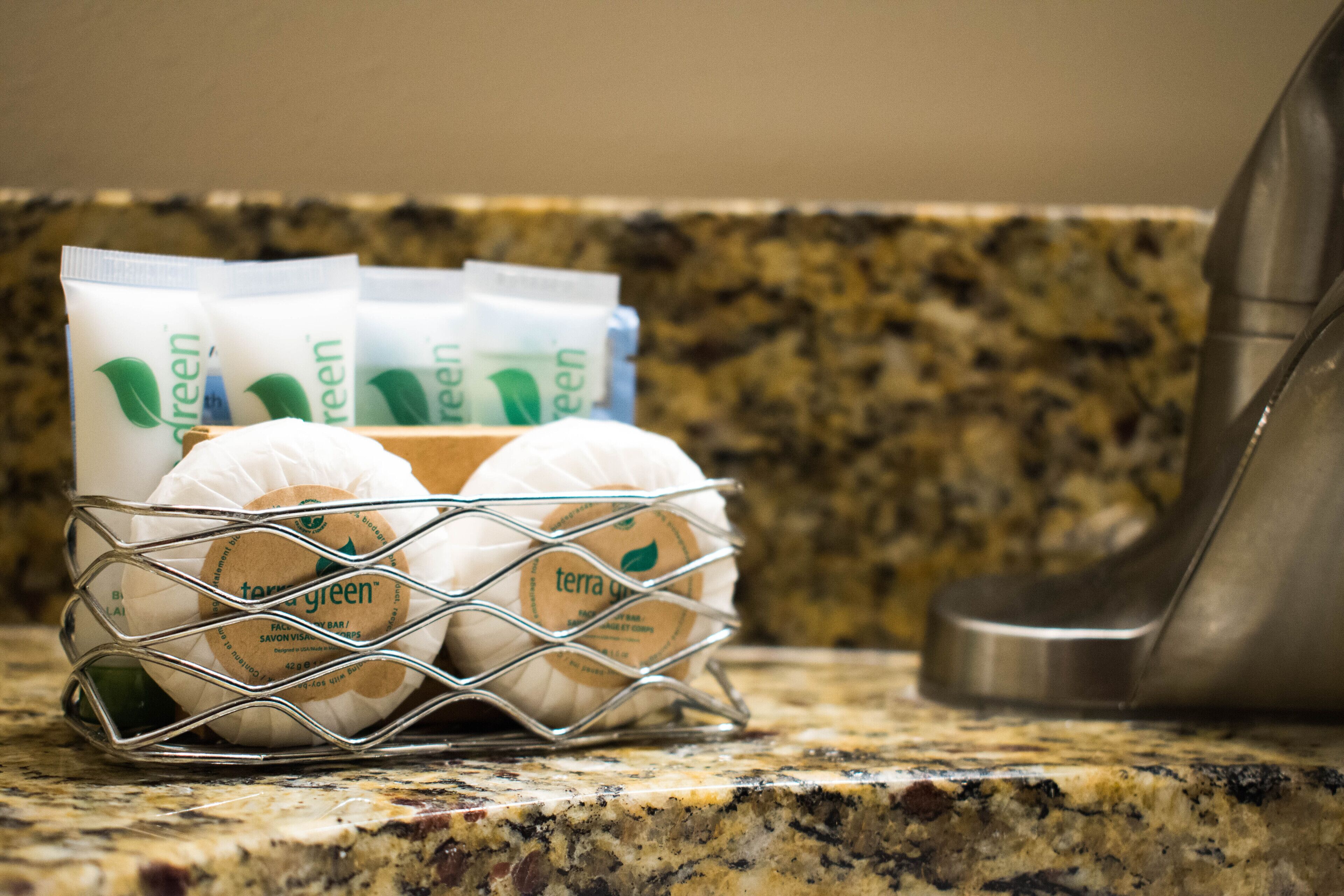 A kitchen counter with a wire basket containing several packets labeled "terra green."
