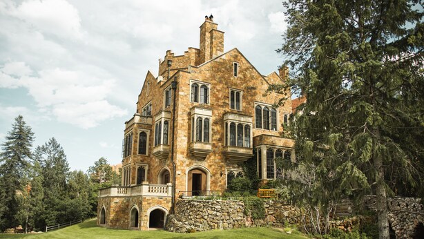 A large, historic stone building with multiple windows and a stone facade. - Glen Eyrie Castle & Conference Center A Ministry of the Navigators (Colorado Springs)