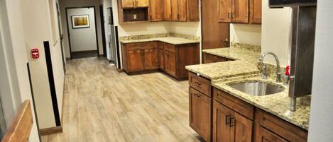 A kitchen with wooden cabinets, granite countertops, and stainless steel appliances.
