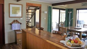 A wooden bar area with a fruit plate, a staircase, and a view of the outdoors. - The gallery - eco-friendly atmosphere (Vacy)