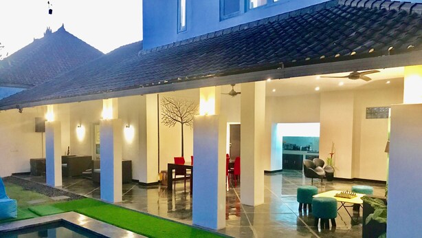 Uma casa moderna com piscina, área de refeições e cozinha.