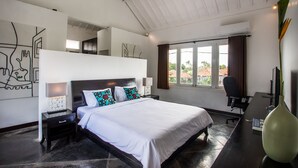 Quarto moderno com cama grande, escrivaninha e janela com cortinas.