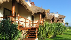 A resort with a thatched-roof building, wooden staircase, and lush greenery. - VILLA ISLA MUJERES MAYAKITA, FANTASTIC OCEAN VIEW & ROOFTOP (Meteorológico)