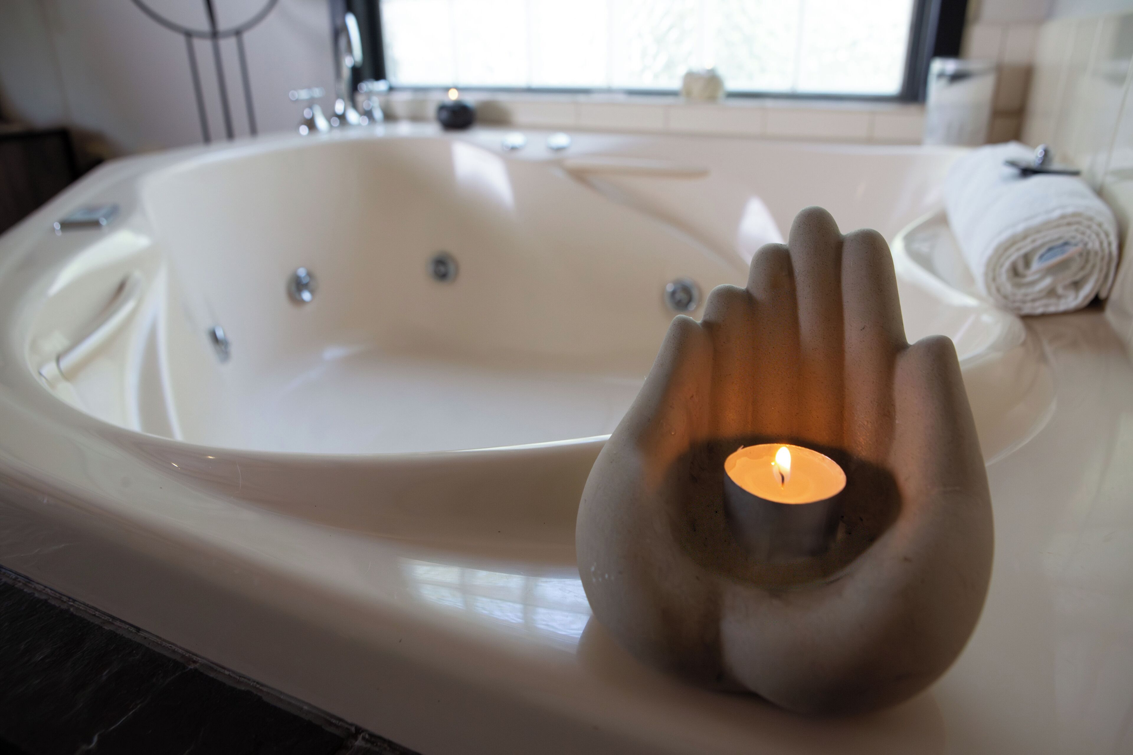 Une baignoire dotée d’un porte-bougie en forme de main.