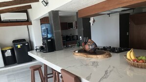 A modern kitchen with a marble countertop, a decorative vase, and a fruit bowl. - Casa Pelicano by B&G - Beach Front Villa Cancún Hotel Zone (Cancún)
