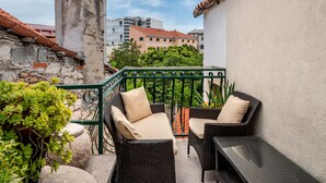 A balcony with wicker furniture and a stone pillar. - How To Live Better In Split, Apartment  (Split)