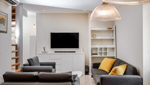 A modern living room with a flat-screen TV, grey sofas, and a white entertainment unit. - How To Live Better In Split, Apartment  (Split)