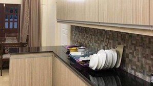 Une cuisine moderne avec des meubles en bois, un plan de travail noir et un pare-feu en carreaux.