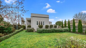 A modern two-story house with a well-maintained lawn and a variety of shrubs and flowers. - Hamilton house - private, central & sunny! (Hamilton)