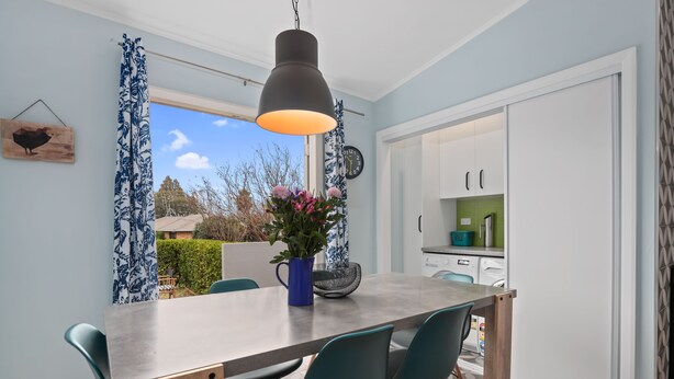 A dining area with a table, chairs, a hanging light fixture, a potted plant, and a view of the outside. - Hamilton house - private, central & sunny! (Hamilton)