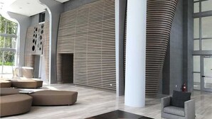 Ein modernes Interieur mit gewölbten Säulen, einem großzügigen Sitzbereich und einem großen Fenster, das für natürliches Licht sorgt.