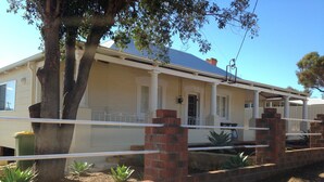 A two-story house with a balcony, brick walls, and a tree in the foreground. - Family Friendly, light & bright ideal for short or longer stays (York)