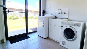 A laundry room with a washing machine, dryer, and a small countertop with a coffee maker. - Hyland Hideaway Yarrawonga (Yarrawonga)