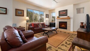 A living room with a fireplace, leather sofa, and a coffee table.