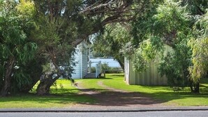 Ein Wohnhaus mit gepflasterter Auffahrt, umgeben von üppigem Grün und Bäumen.