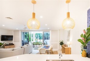 Relax in this stylish living space with a central island, sofa, and dining table.