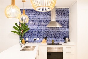 Enjoy cooking in this well-equipped kitchen with an oven, stainless steel sink, and ample countertop space.