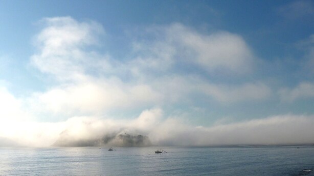 A calm sea with a few boats and a distant landmass partially obscured by fog. - 'Seabreeze' a unique Waterfront/Beachside property (Pearl Beach)