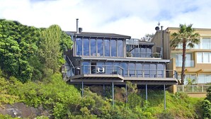 Un immeuble à plusieurs étages doté de grandes fenêtres, d’un balcon et d’une bouée de sauvetage.
