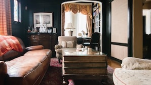 A cozy living room with a leather sofa, a wooden coffee table, and a patterned rug. - Harvard House--Make Your 2026 Family Gathering An Unforgettable Experience (Waltham)