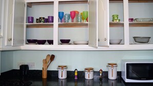 Eine Küche mit offenen Schränken, die buntes Glas und Geschirr zeigen.