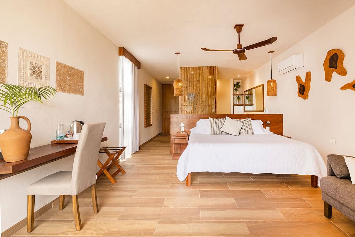 Un dormitorio moderno con cama, escritorio, silla, sofá y mesa de comedor.