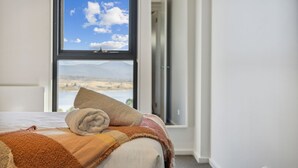 Una cama con vistas a un paisaje montañoso a través de una ventana.