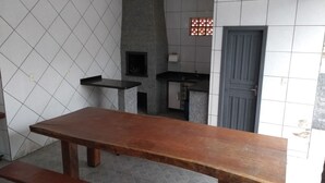 Una cocina con una mesa de madera, una encimera negra, un salpicadero de azulejos y una puerta.