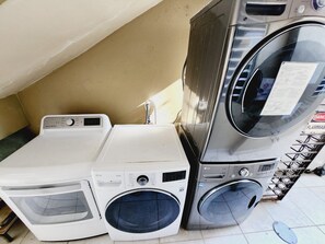 A laundry area with stacked washing machines and dryers. - Compact Haven with Private Entrance and FREE Parking and Laundry (Ponce)