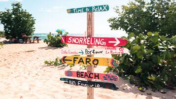 A beach signpost with directions to various activities.