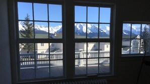 A room with large windows offering a view of snow-capped mountains.