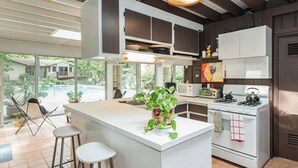 A modern kitchen with white cabinetry, a central island, and a view of the outdoors.
