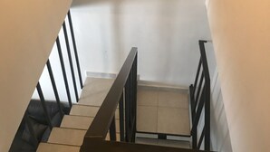 A staircase with black railings and beige tiles. - BEAUTIFUL CONDO IN ROSARITO (VILLA SERENA) (Predios Urbanos)