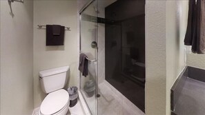 A bathroom with a toilet, a glass shower enclosure, and a towel rack. - Beachcomber unit 608 (Longboat Key)