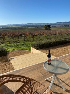 Un patio con una mesa, una botella de vino y dos copas.