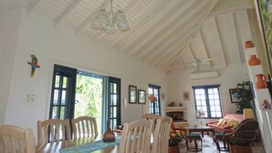 A spacious living room with high ceilings, a dining area with wooden chairs, and a fireplace. - Mock Turtle is an Enchanting & Affordable Retreat! (Black Rock)