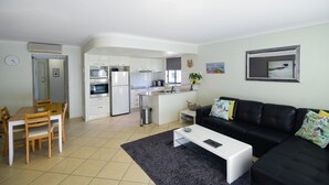 Un appartement moderne comprenant une cuisine, un coin repas et un salon.