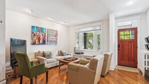 Una sala de estar moderna con un conjunto de sofá, una mesa de centro y obras de arte en la pared.