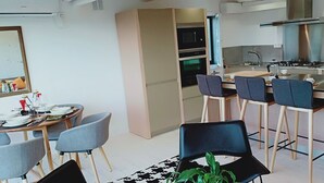 A modern kitchen with a central island, bar stools, and a dining area with a table and chairs. - CASA DA VIÑA (Nogueira de Ramuín - Ourense) Ribeira Sacra  (Ourense)