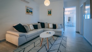 A modern living room with a sectional sofa, a round coffee table, and a patterned rug. - Apartment **** "Lumin 4" 52 m2 (Senj)