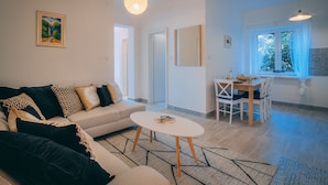 A modern living room with a sofa, coffee table, and dining area. - Apartment **** "Lumin 4" 52 m2 (Senj)