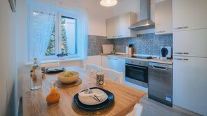 A modern kitchen with white cabinets, a stainless steel oven, and a dishwasher. - Apartment **** "Lumin 4" 52 m2 (Senj)