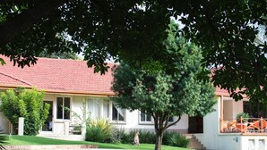 A house with a red-tiled roof, a swimming pool, and a covered patio area.
