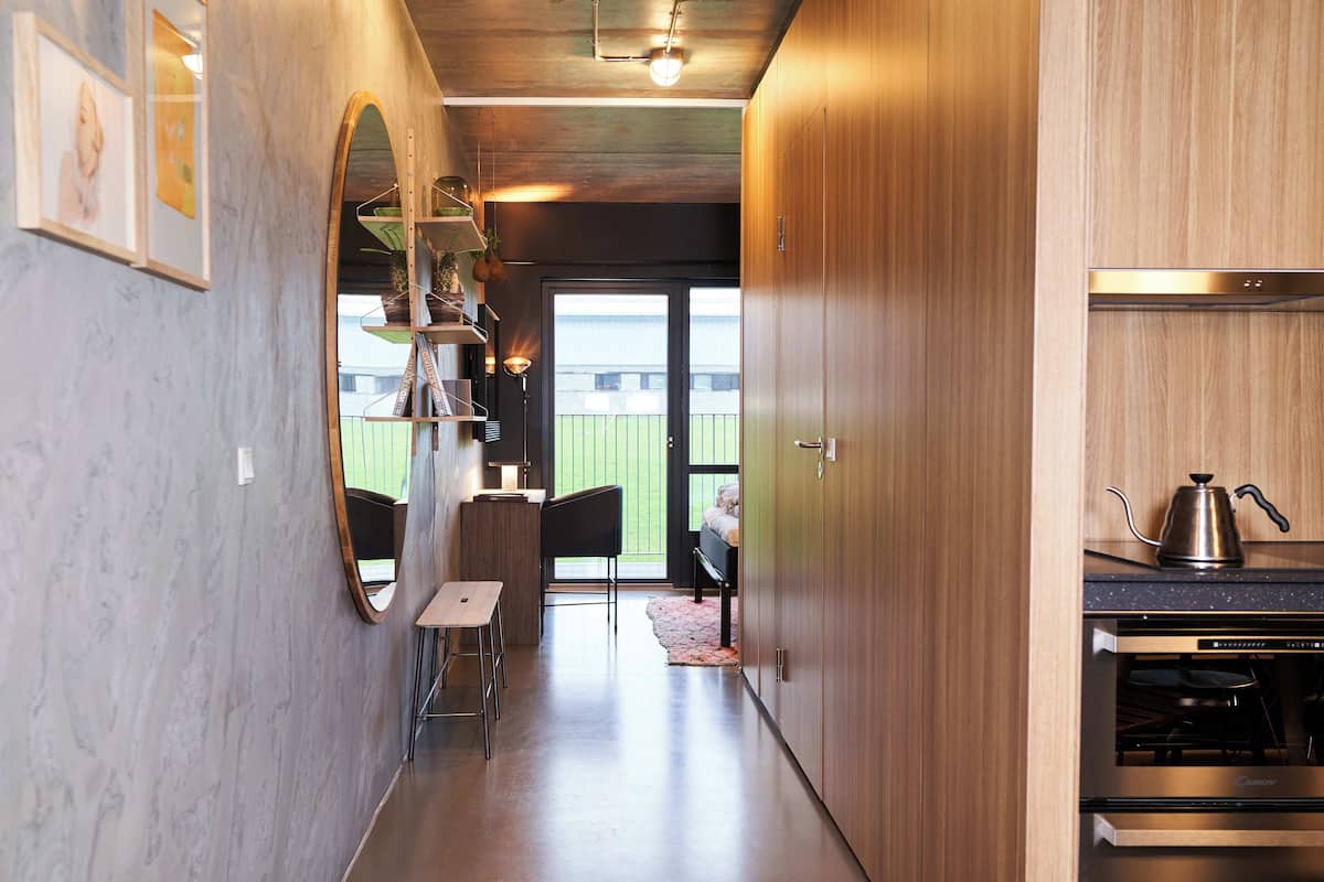 A modern kitchen with a built-in oven and a coffee maker on the counter.