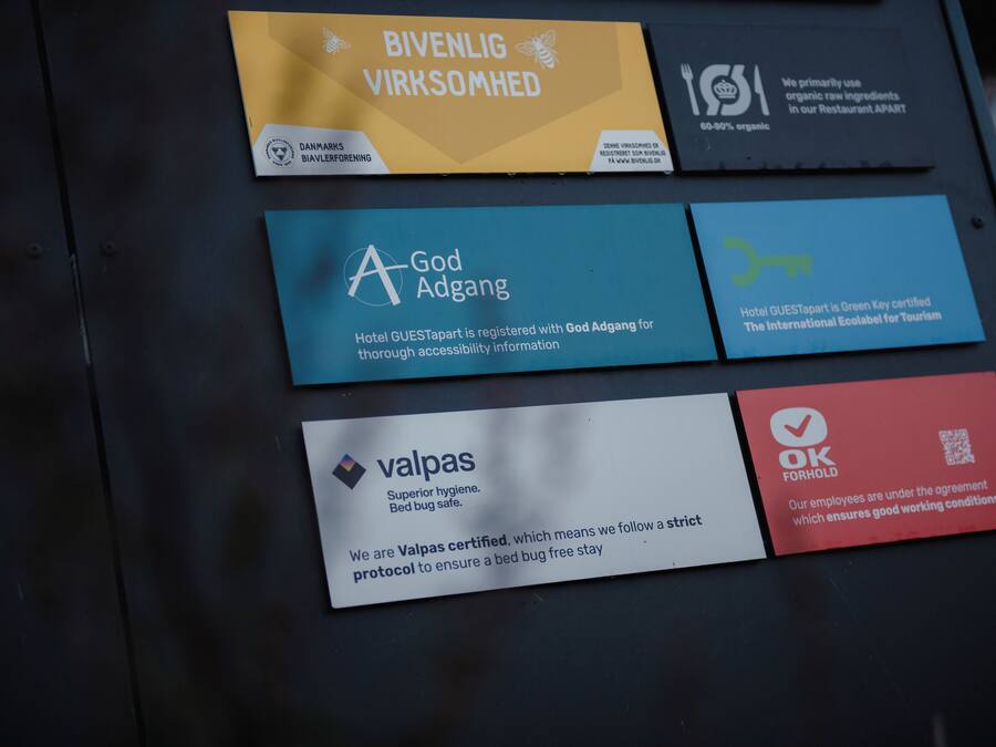 Four hotel certification badges on a wall.