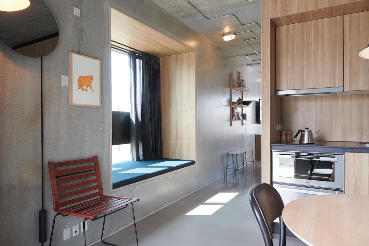A modern kitchen with a built-in oven and a window with curtains.