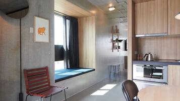 A modern kitchen with a built-in oven and a window with curtains.