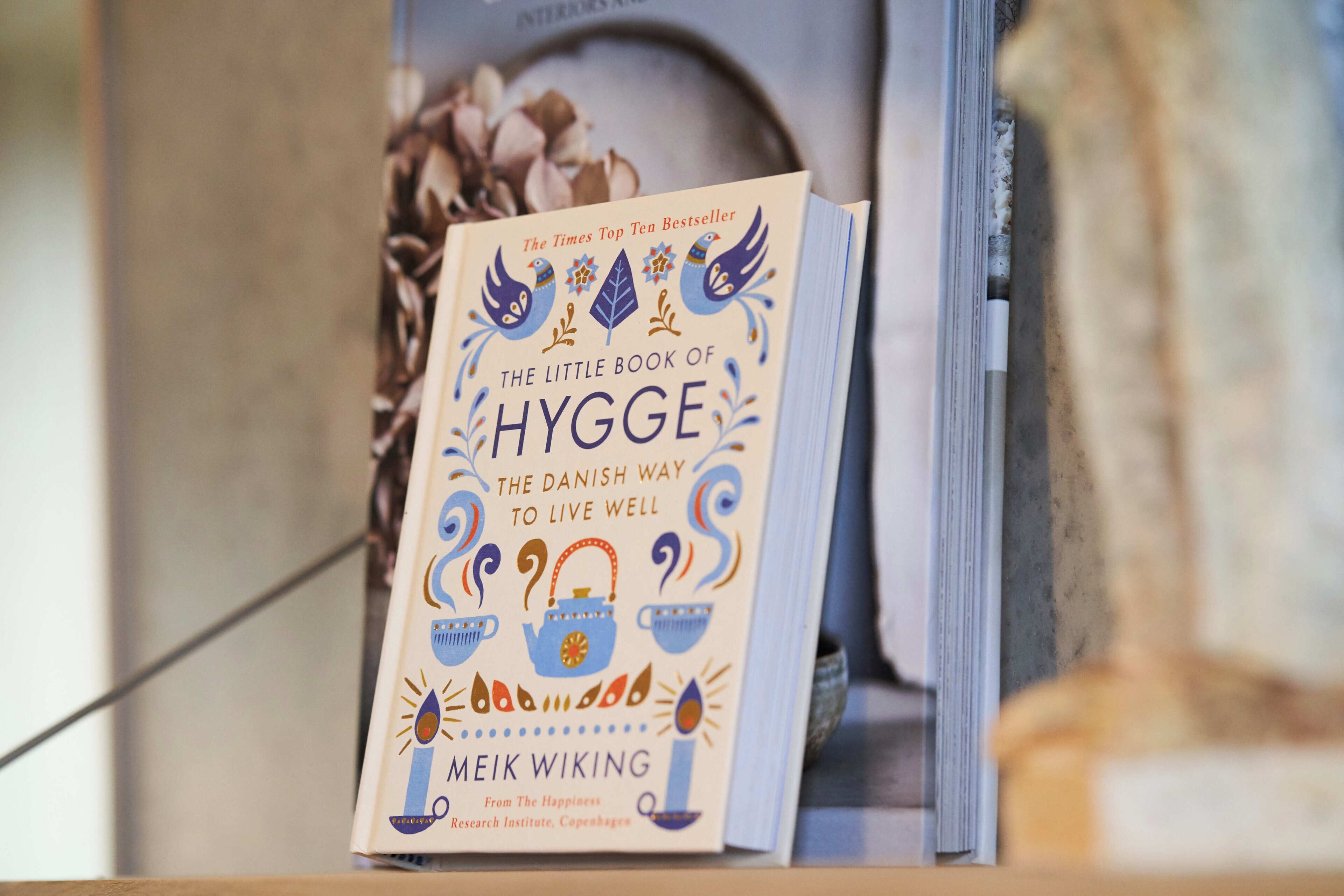A book titled "The Little Book of Hygge" by Meik Wiking, displayed on a shelf.