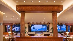 A spacious lobby with a large seating area, a view of the beach, and a wooden decorative structure. - PRICES REDUCED! HYATT RES. CLUB-OCEAN FRONT, MAUI MAY 23-30, & MAY 30-JUNE 6. (Lahaina)